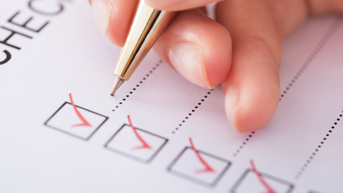 Hand som skriver i en checklista.